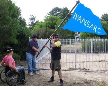 Left to right Frank VK3ZO, Mark VK3PI, Dave VK3FTDX hoist the WANSARC flag